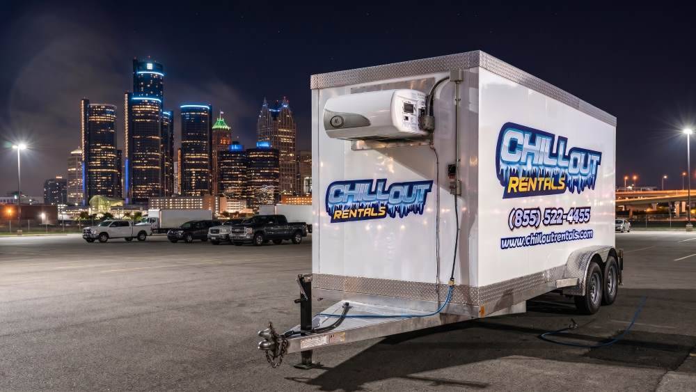 Chill Out Rentals cooler trailer parked in Detroit Michigan with city skyline at night